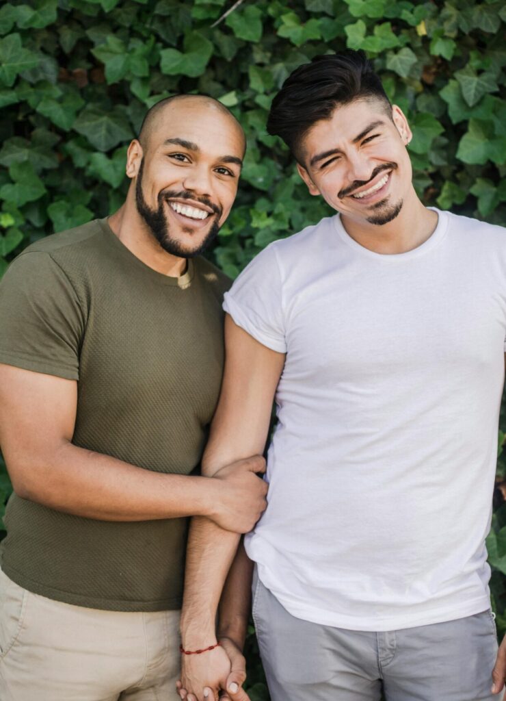 Photo of gay men holding each other and smiling to the camera